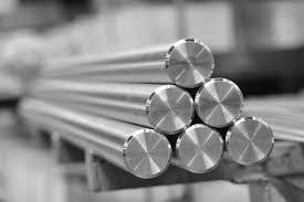 Polished stainless steel round bars stacked in a warehouse for manufacturing use